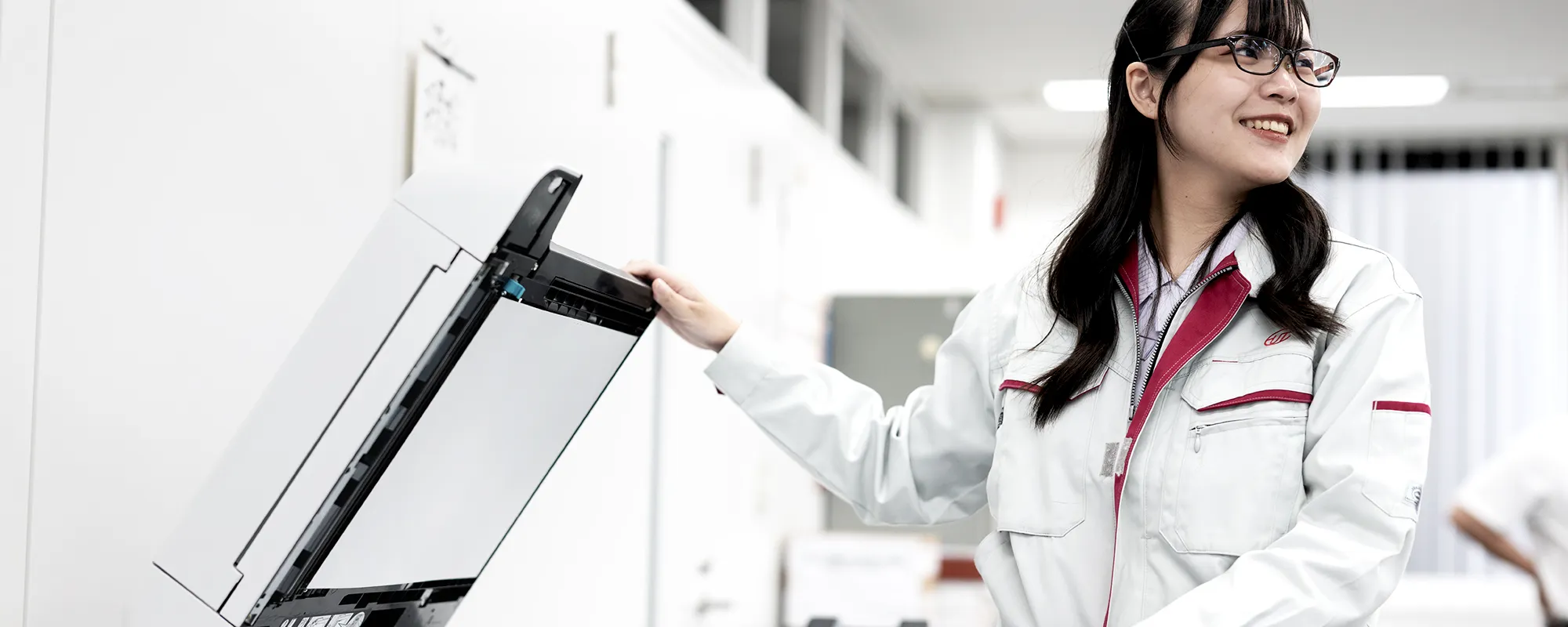 コピーをして笑顔で振り返るスタッフの写真